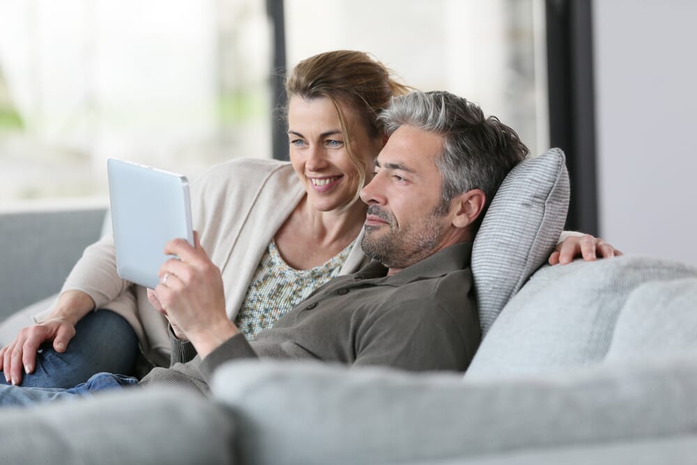 couple on the sofa looking at a tablet together