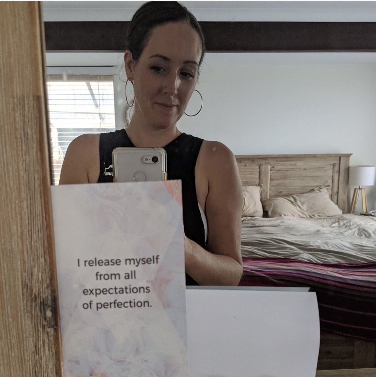 woman holding sign that says i release myself from all expectations of perfection