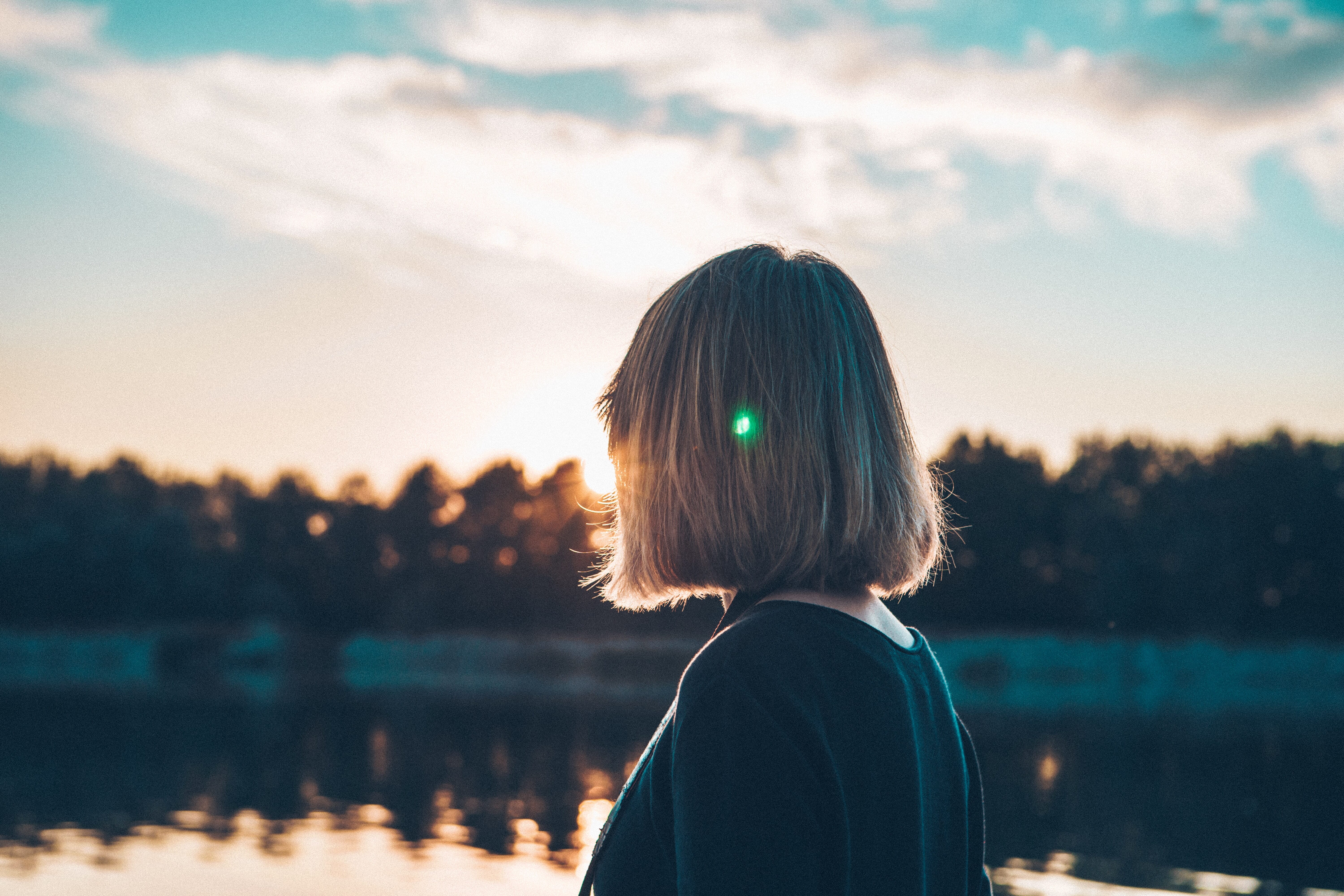 woman watching the sunrise over a lake