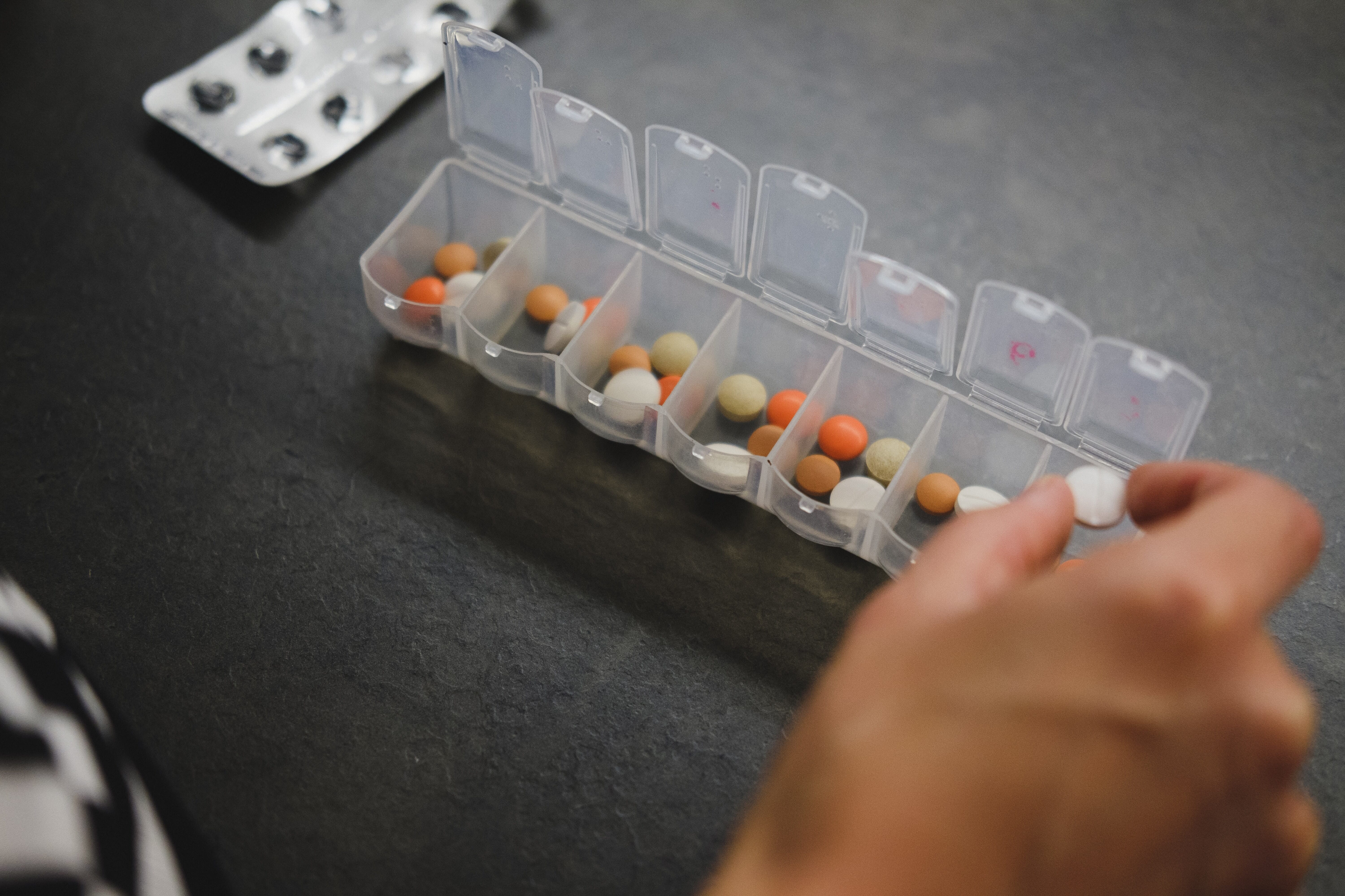 daily pill case full of ivf medications and fertility supplements