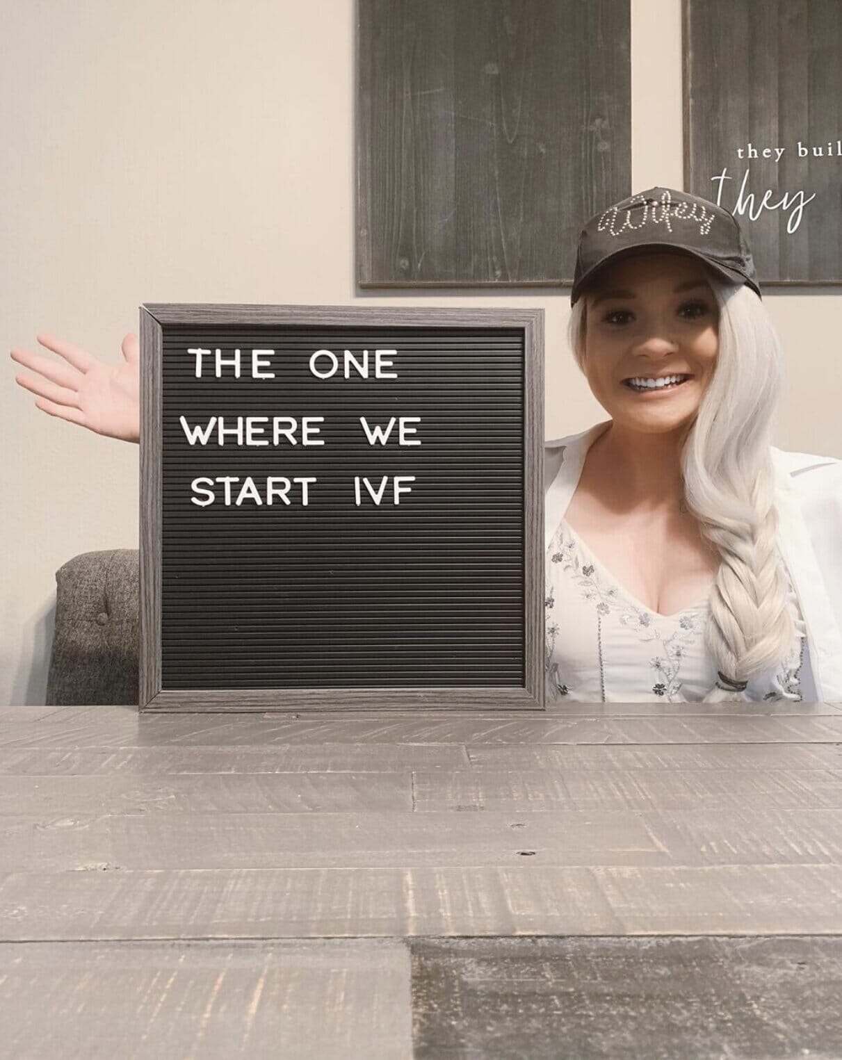 infertility warrior melissa pomish holding a sign that reads &quot;the one where we start ivf&quot;