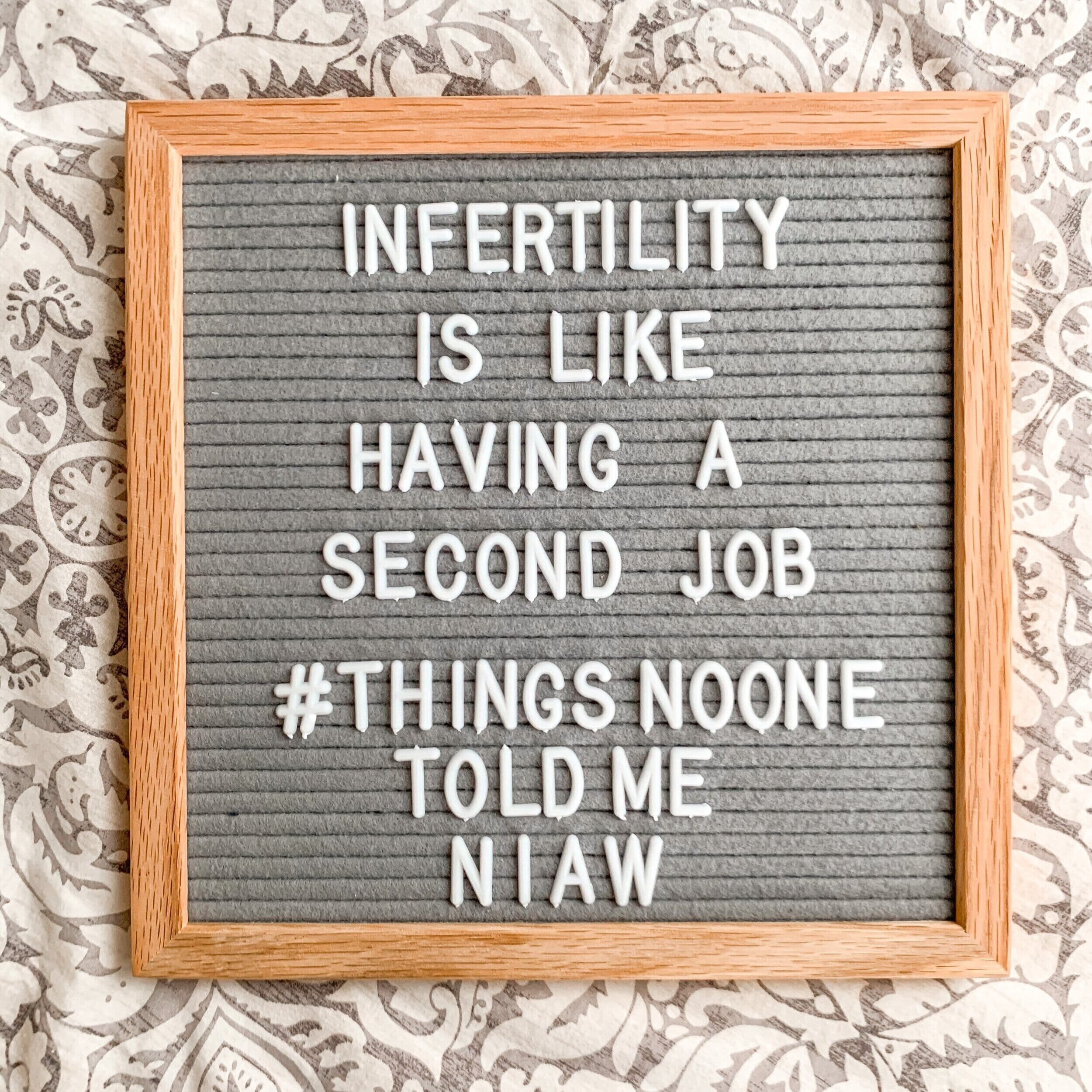 sign that reads "infertility is like having a second job"