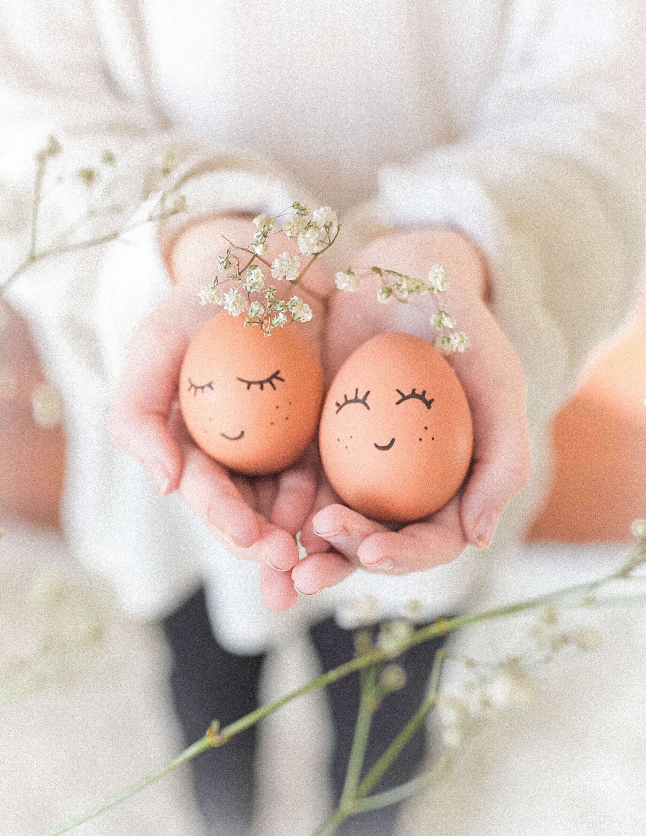 woman holding two eggs with smiley faces drawn on them