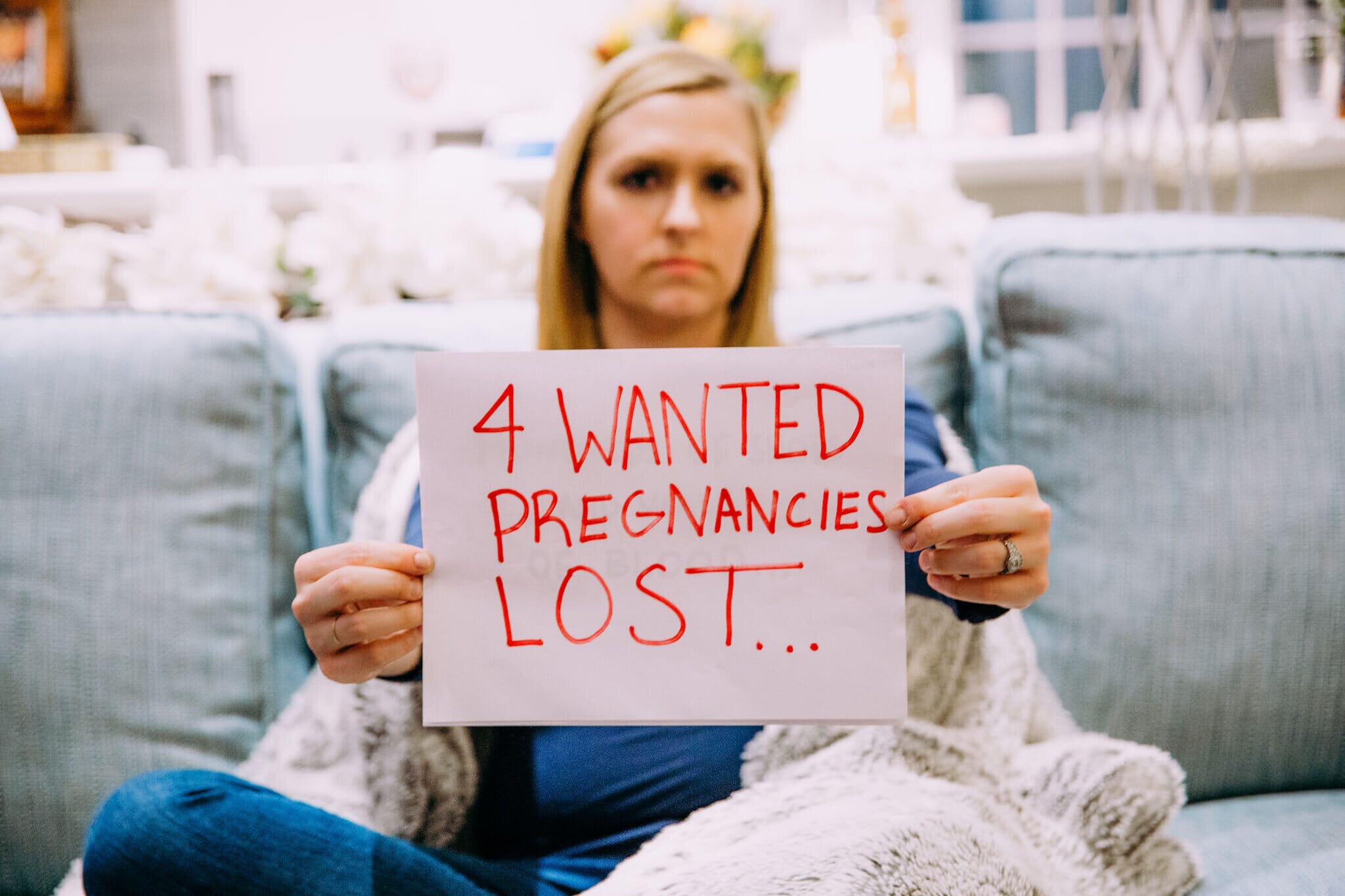 dr. katy huie harrison holding a sign that reads &quot;4 wanted pregnancies lost...&quot;