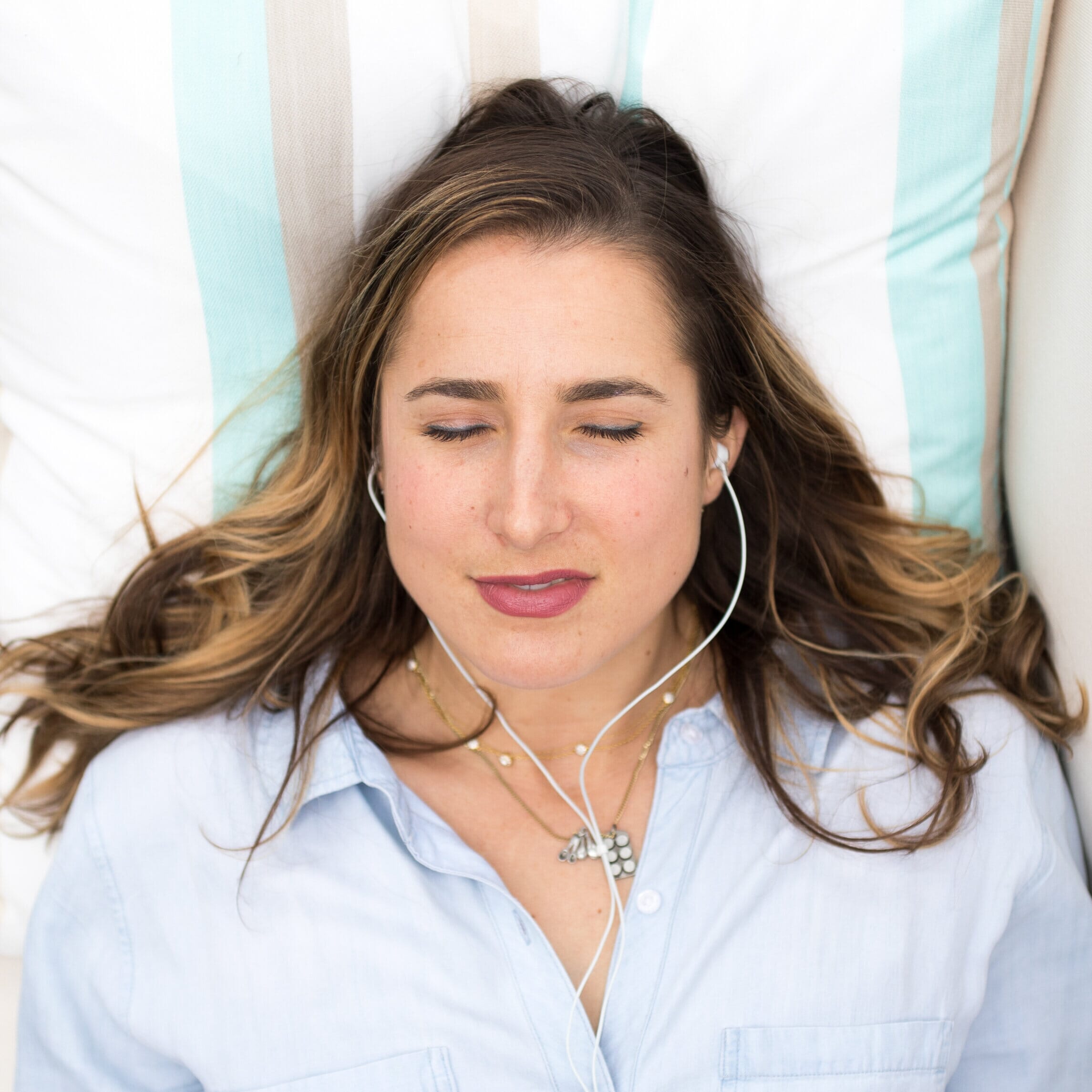 woman meditating with her eyes closed and earphones in