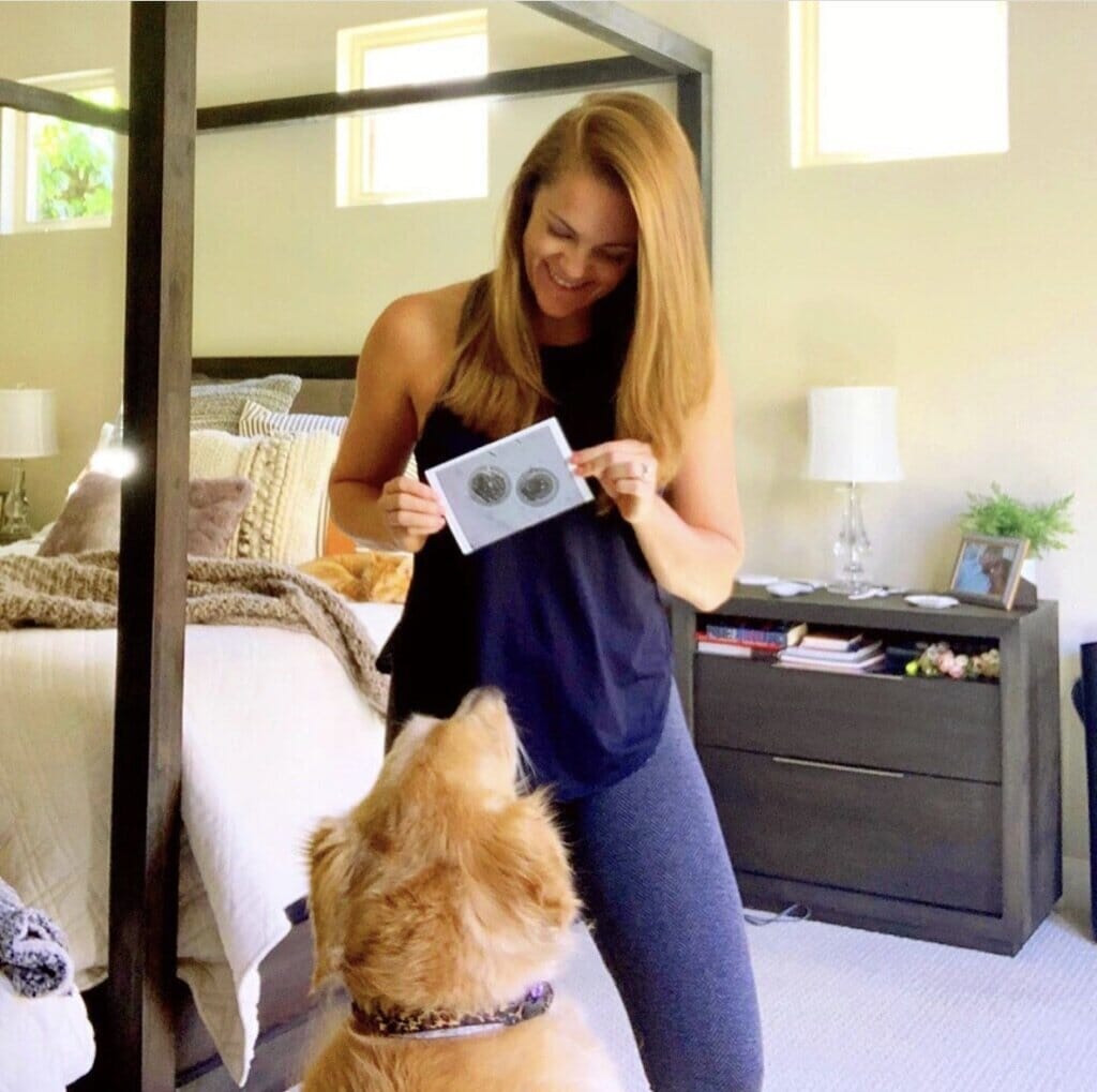 infertility warrior emily attenhofer at home with her dog and a photo of viable embryos