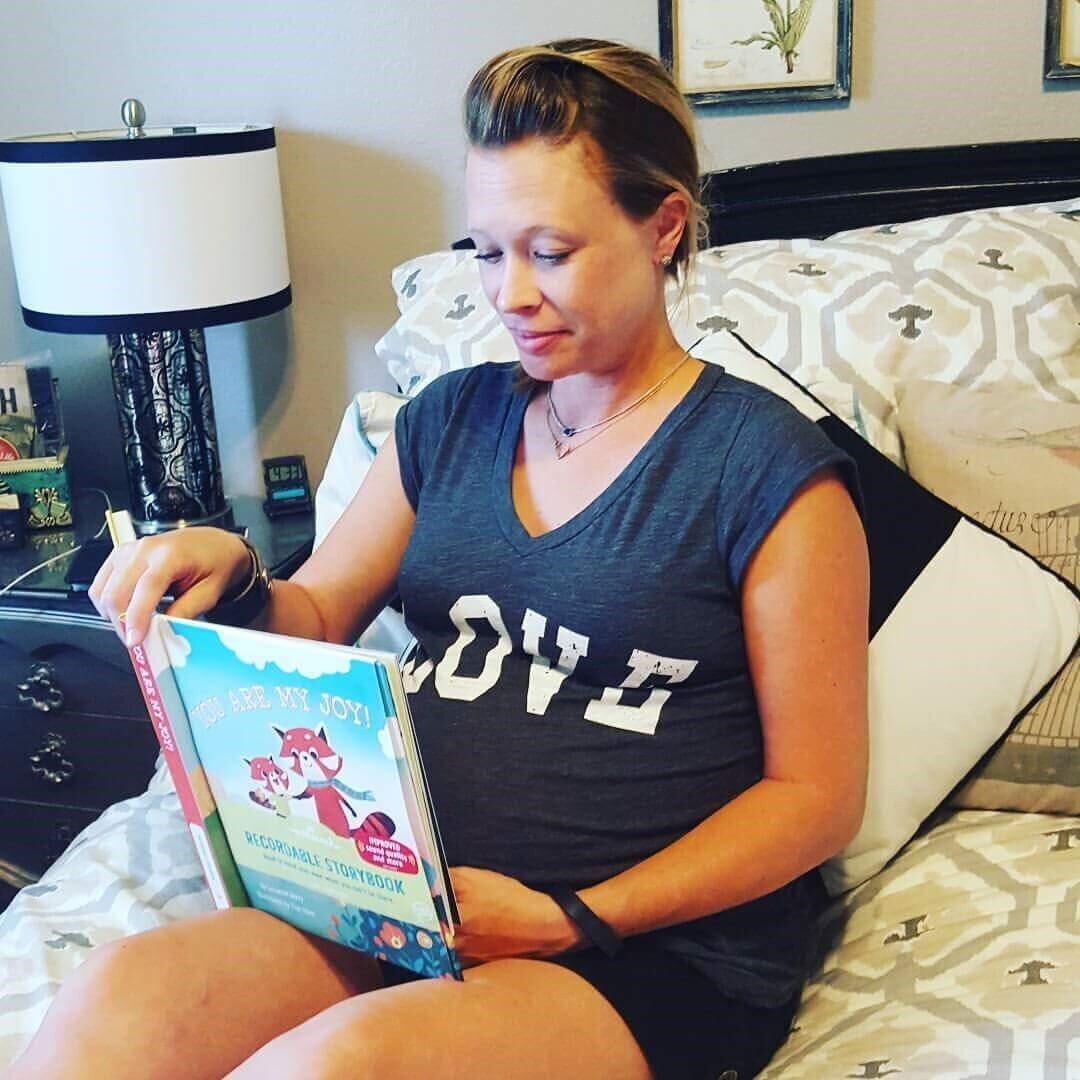 three-time surrogate tiffany jo baker in bed reading a book