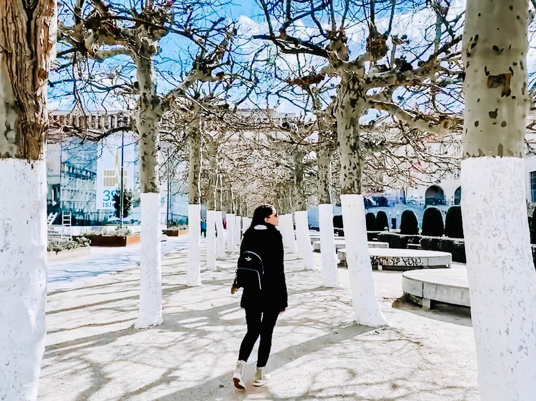 infertility advocate lauren citro walking through a plaza of trees