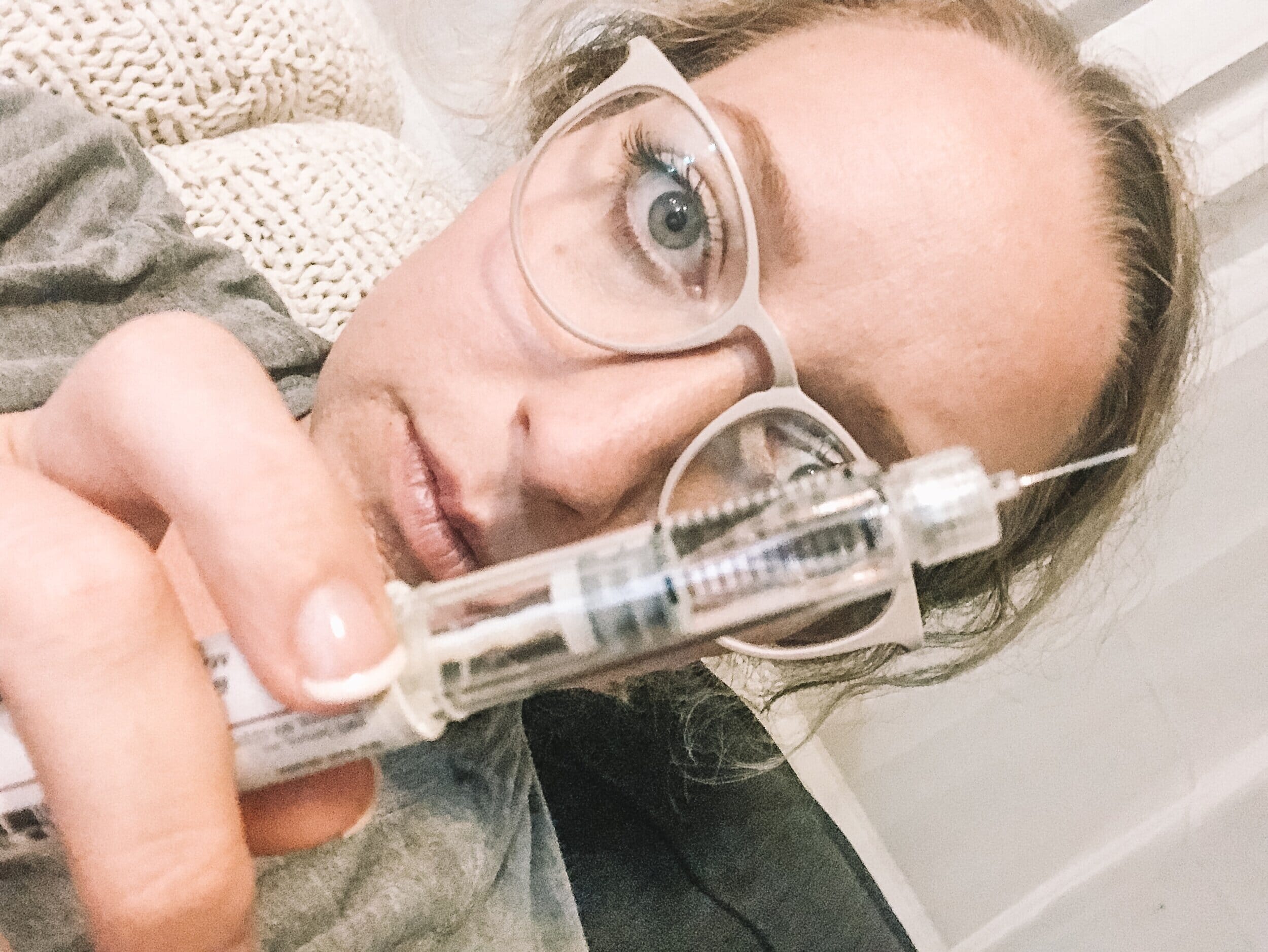 fertility warrior rachel sloan with ivf needle in front of her face