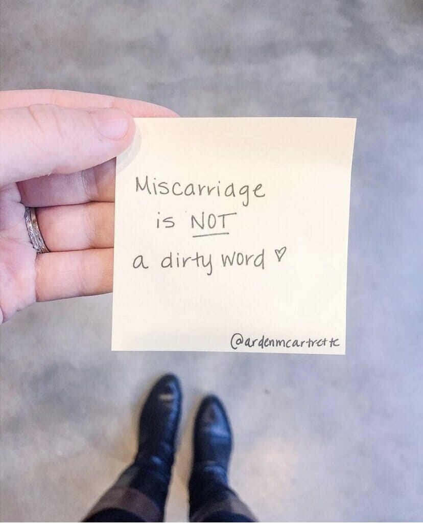woman holding sticky note that reads &quot;miscarriage is not a dirty word&quot;