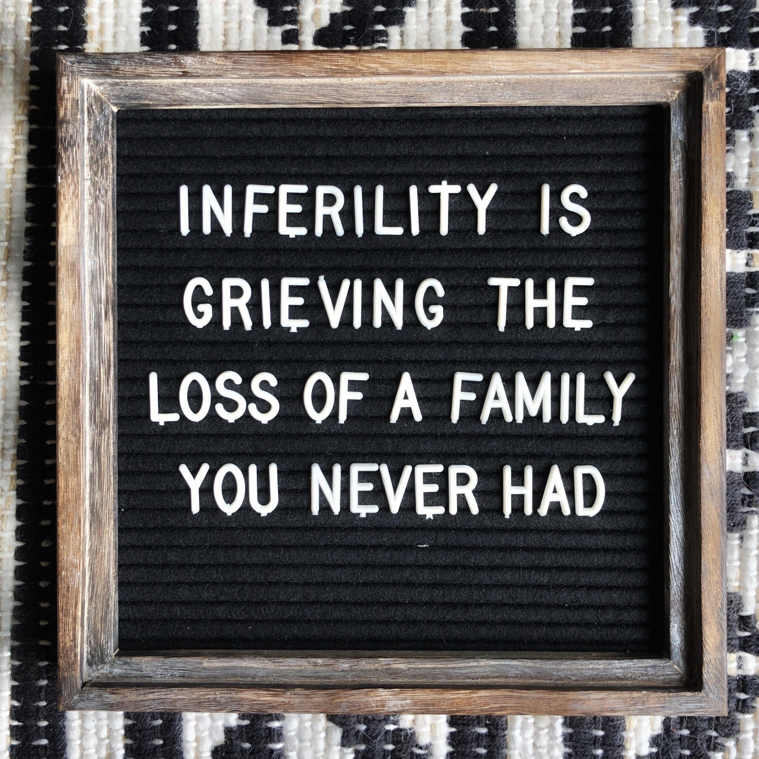 sign that reads "infertility is grieving the loss of a family you never had"
